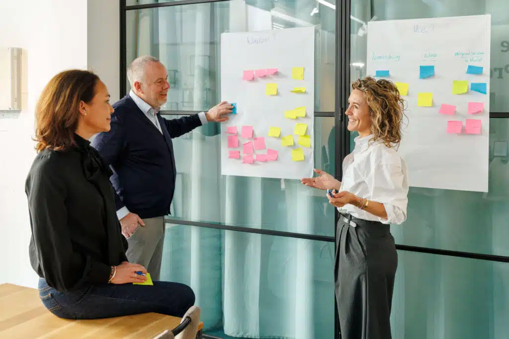 Team van Sociallane staat voor whiteboard met post its erop.